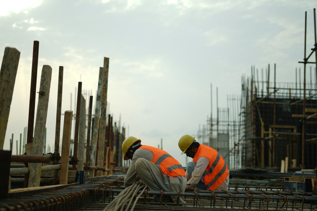 Construction workers in hard hats and safety vests on site.